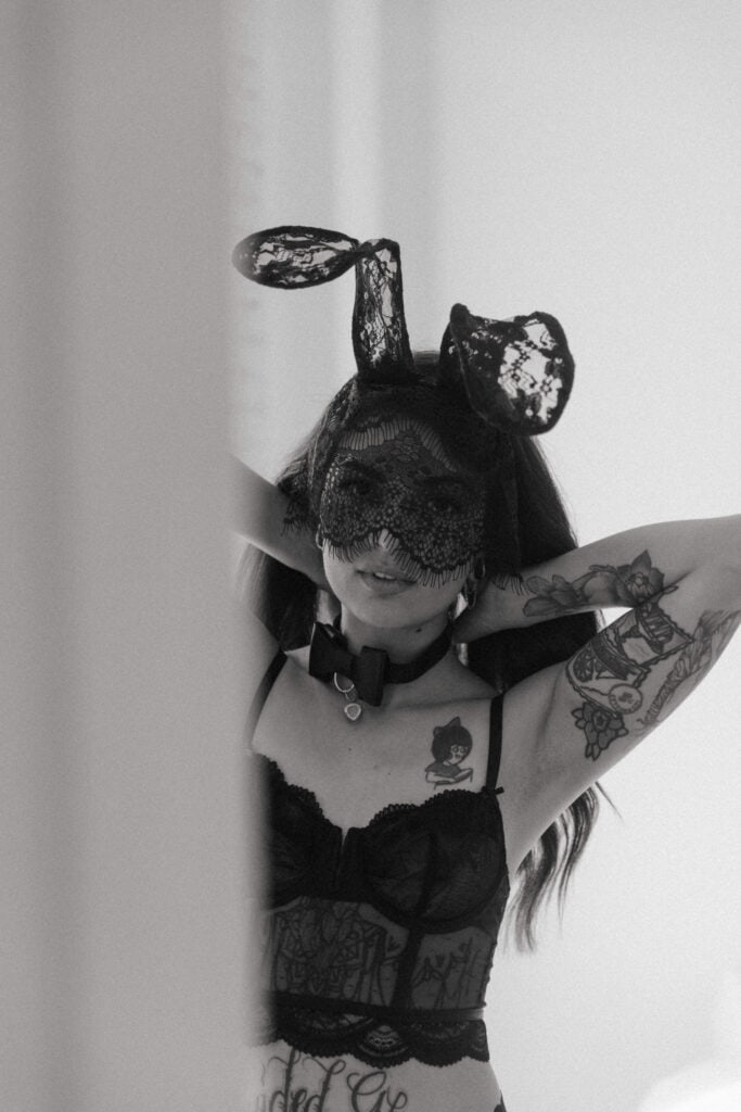 a woman wearing black lace face mask and bunny ears during her boudoir session