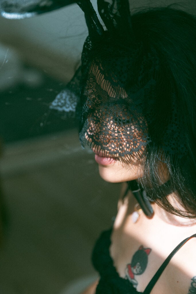 close up of a womans face wearing a lace mask 