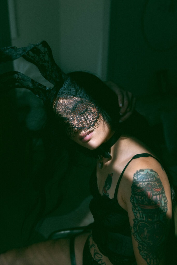 a masked woman posing during her boudoir session 