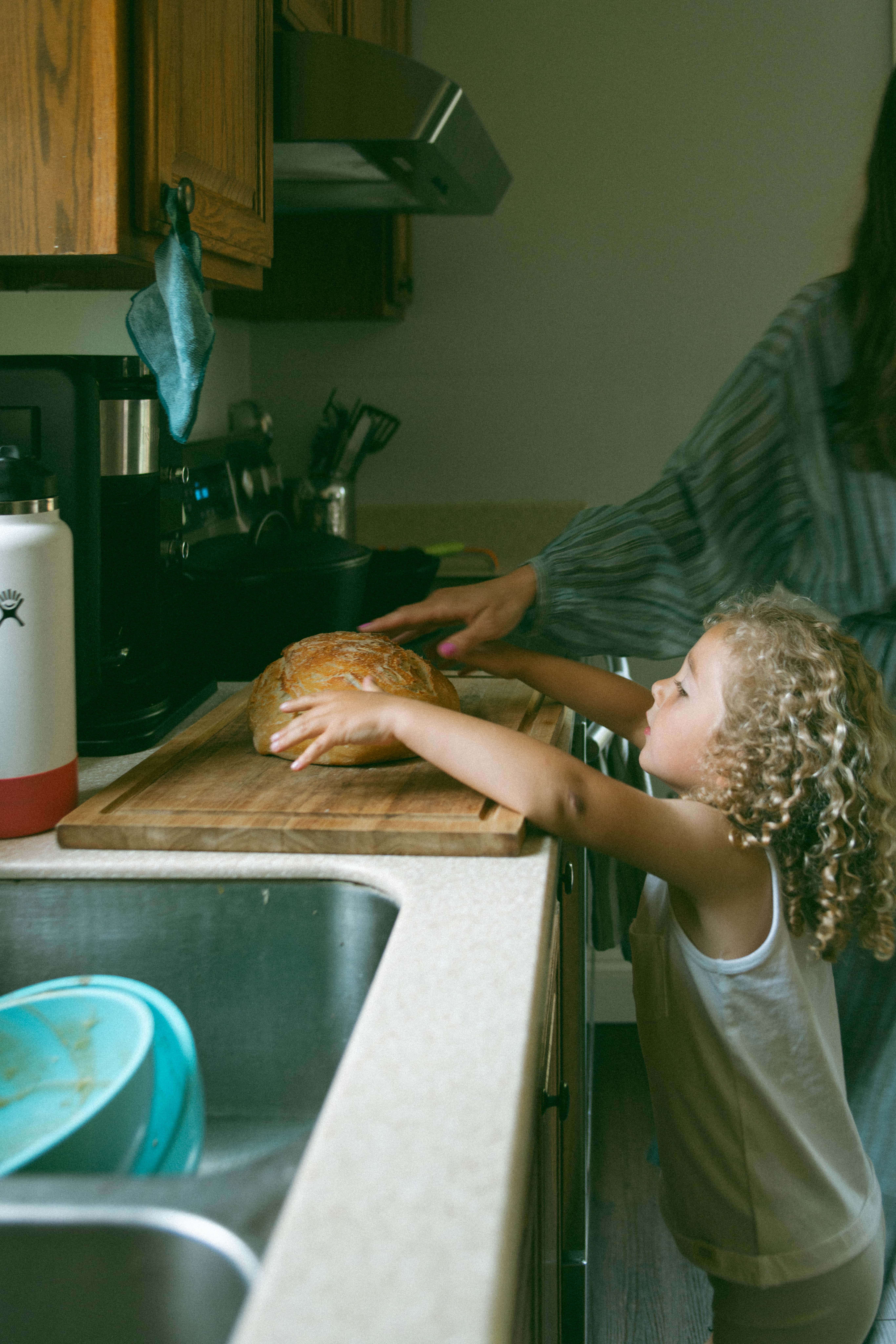 mother and son holding bread on the cutting board