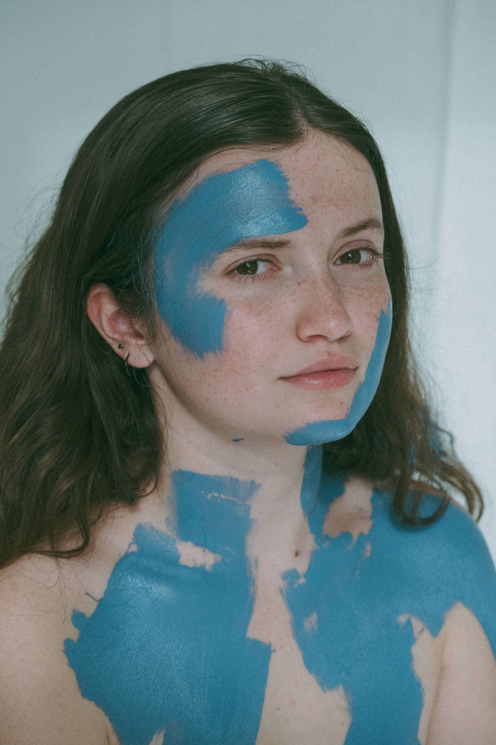 portrait of a woman's face after she painted it blue 