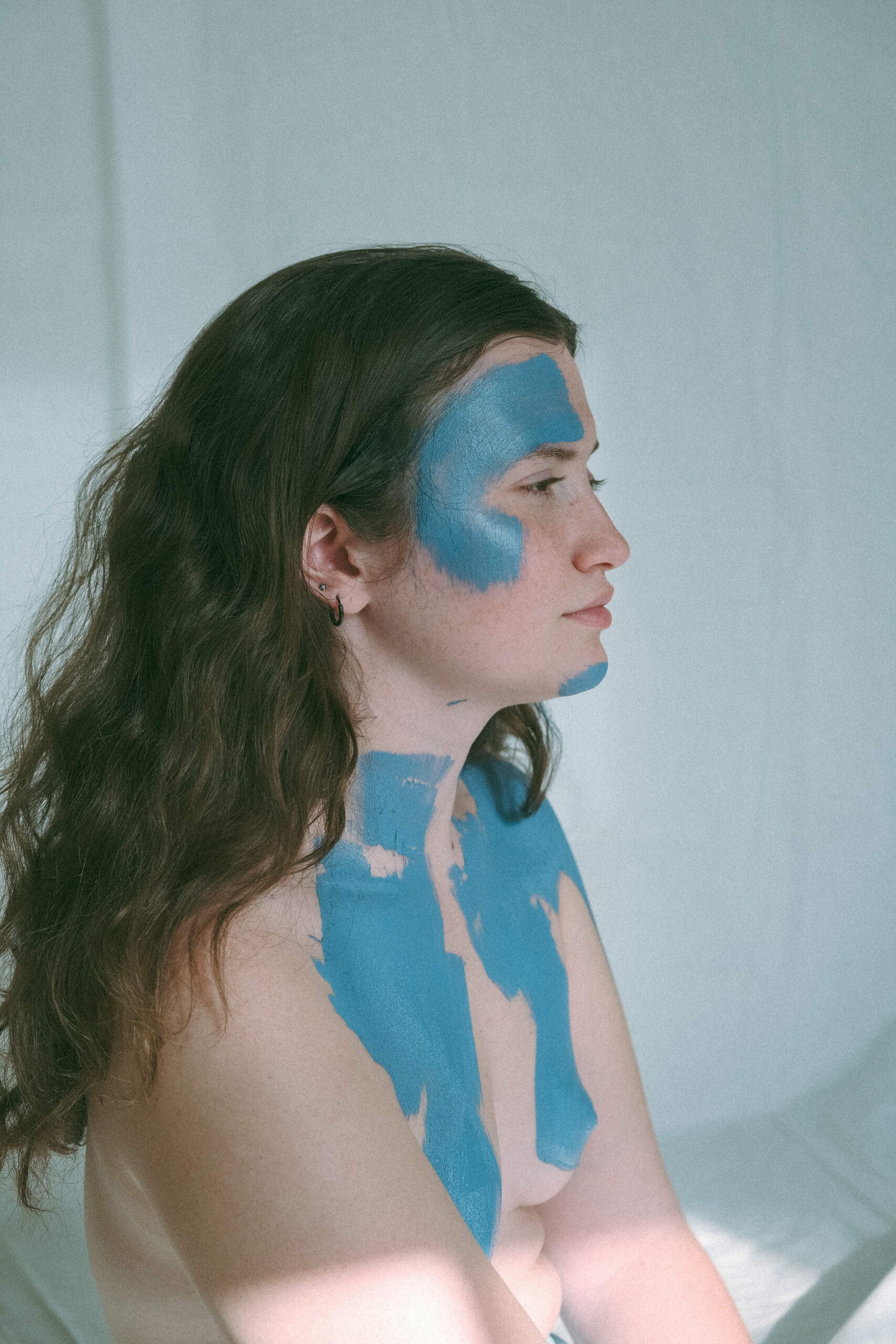 topless woman with blue paint on her face and body 