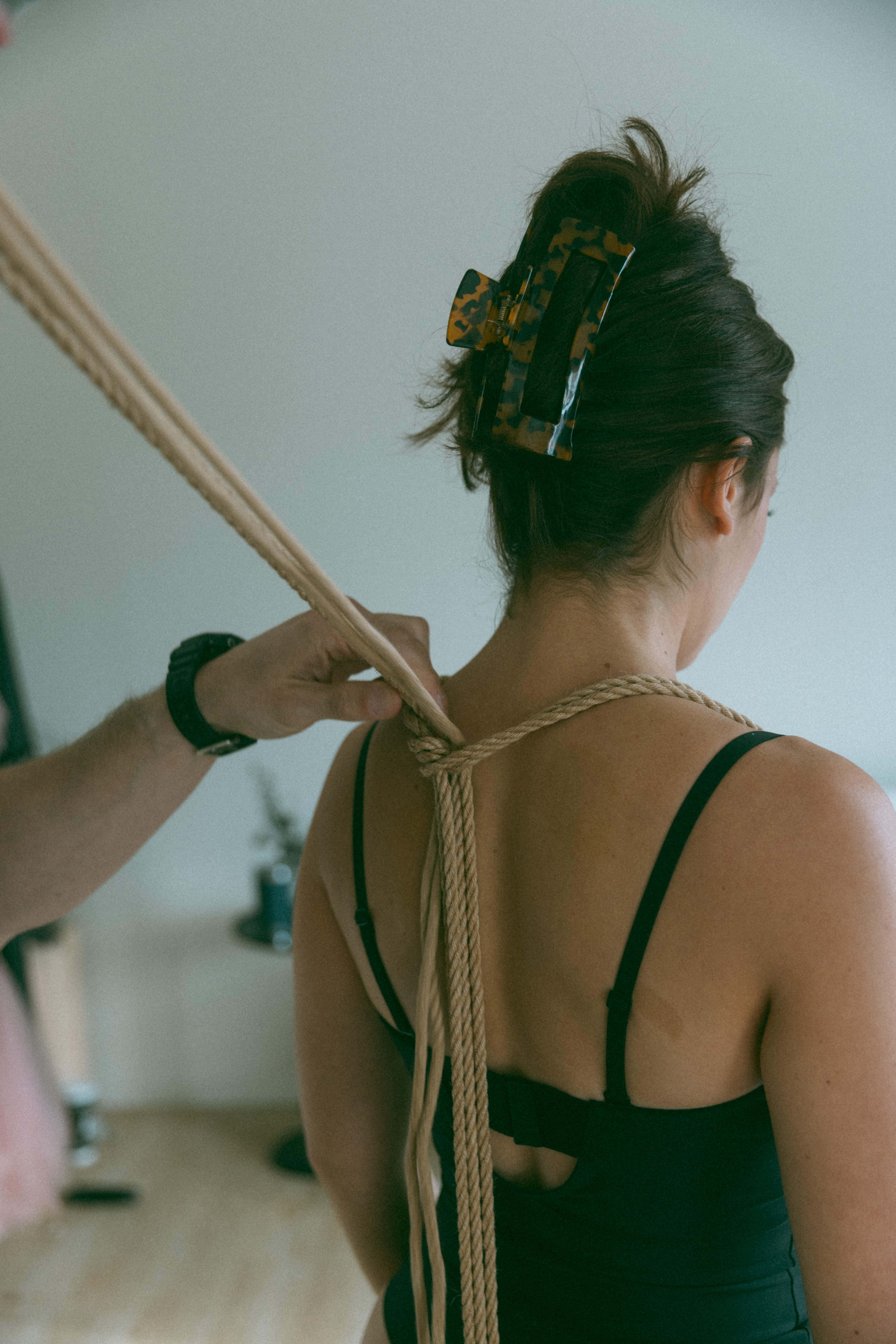 shibari artist tying a rope onto a woman