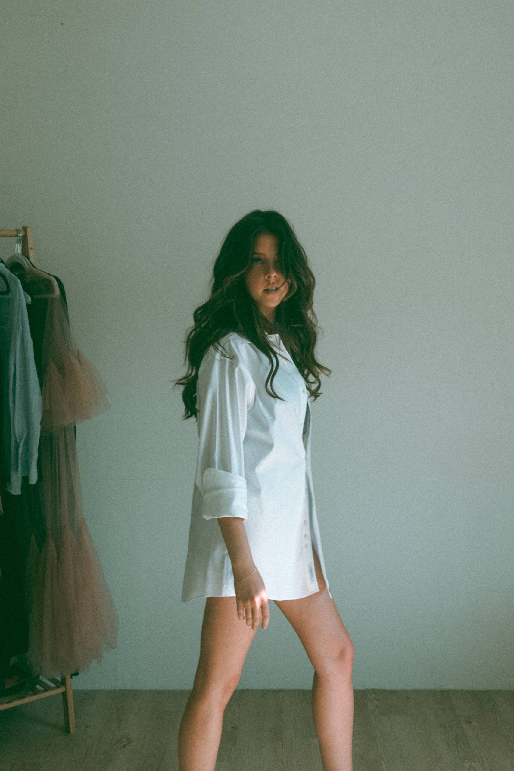 a woman walking in a white oversized shirt during a boudoir session 
