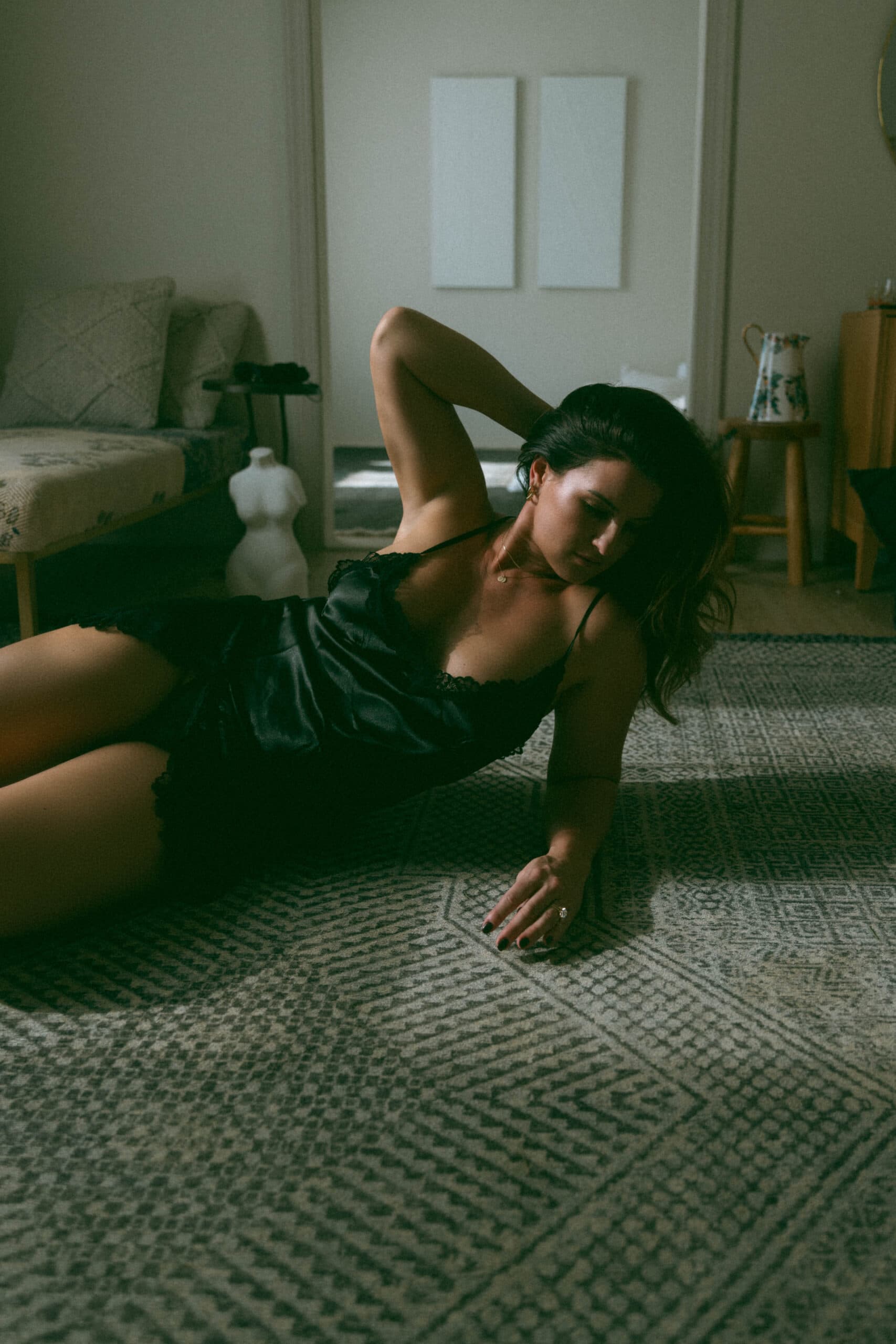 a woman in a silk dress, laying on the floor during a Maryland boudoir shoot 