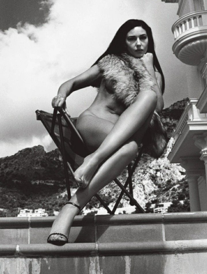 a naked woman sitting on a chair with fur around her neck during a female photoshoot by helmut newton