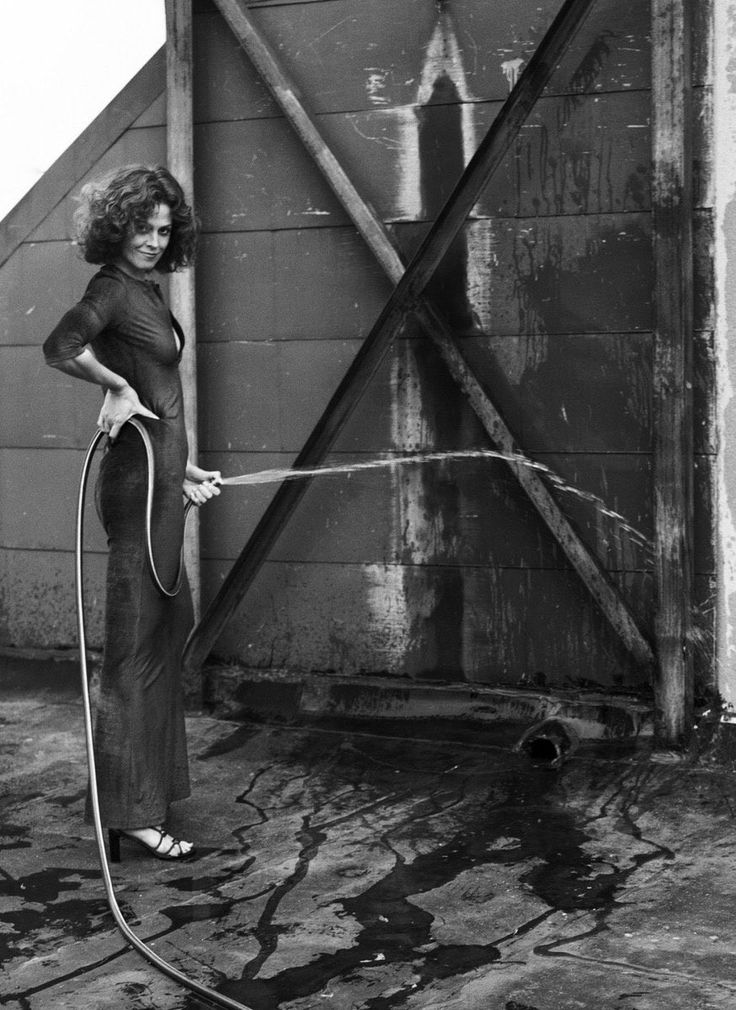 a female photoshoot of a woman spraying a hose 