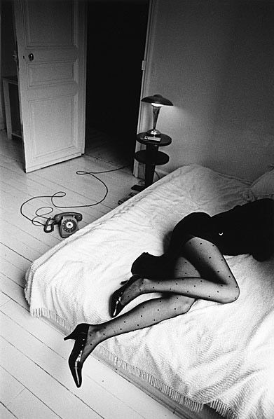 a woman laying in a bed during a female photoshoot by helmut newton