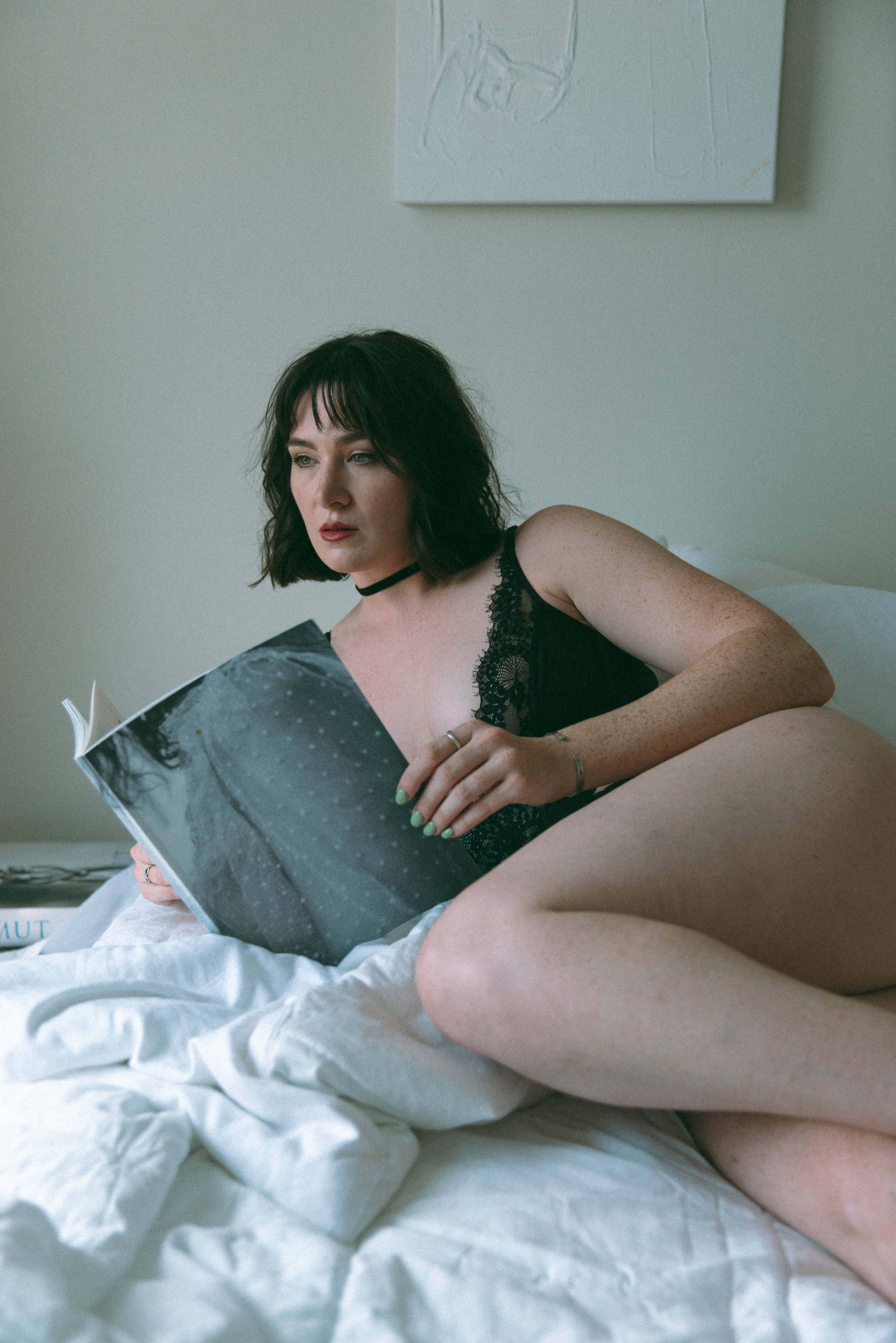 a woman laying on a bed holding a book