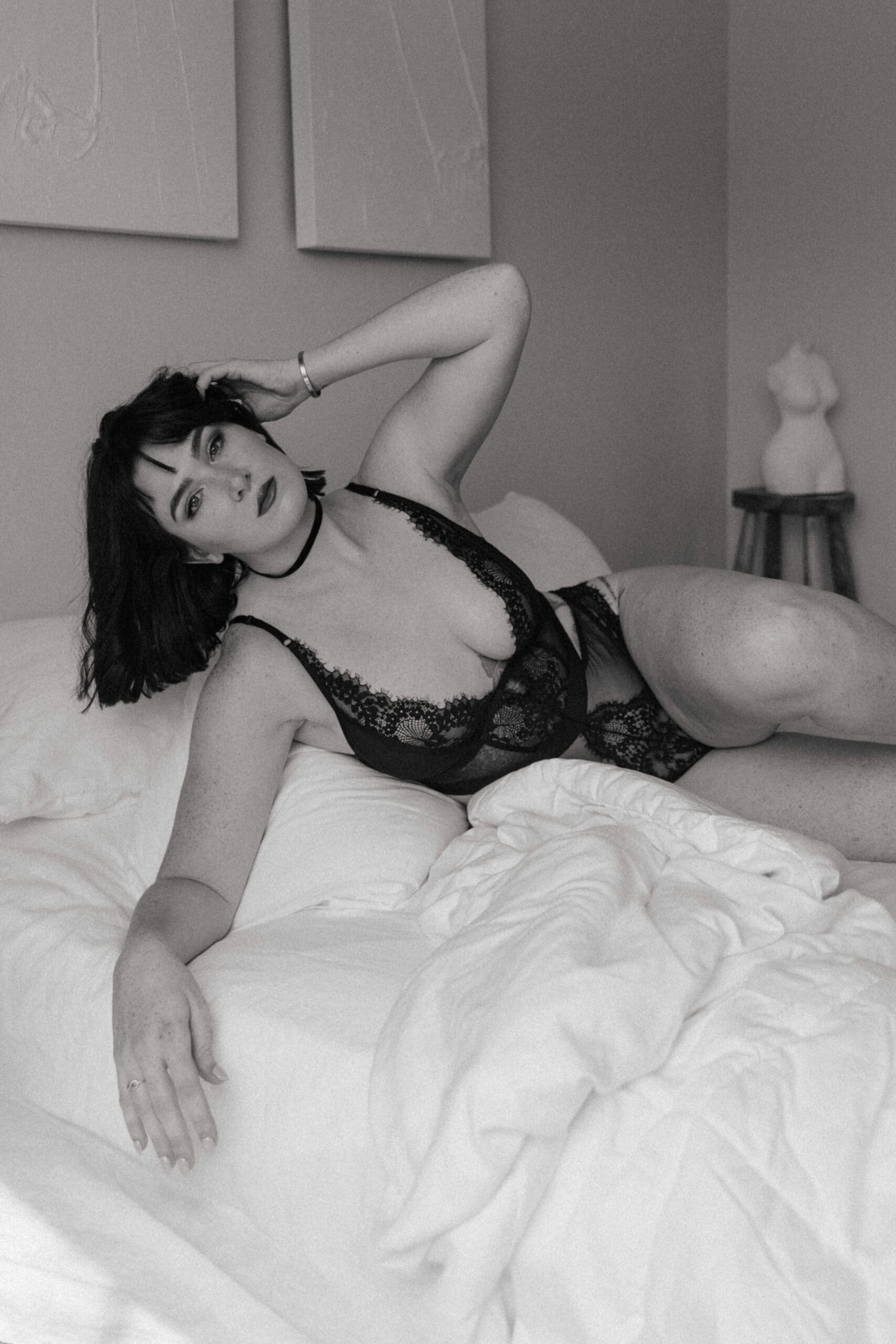 a black and white of a woman in intimates laying on a bed captured by a Maryland boudoir photographer