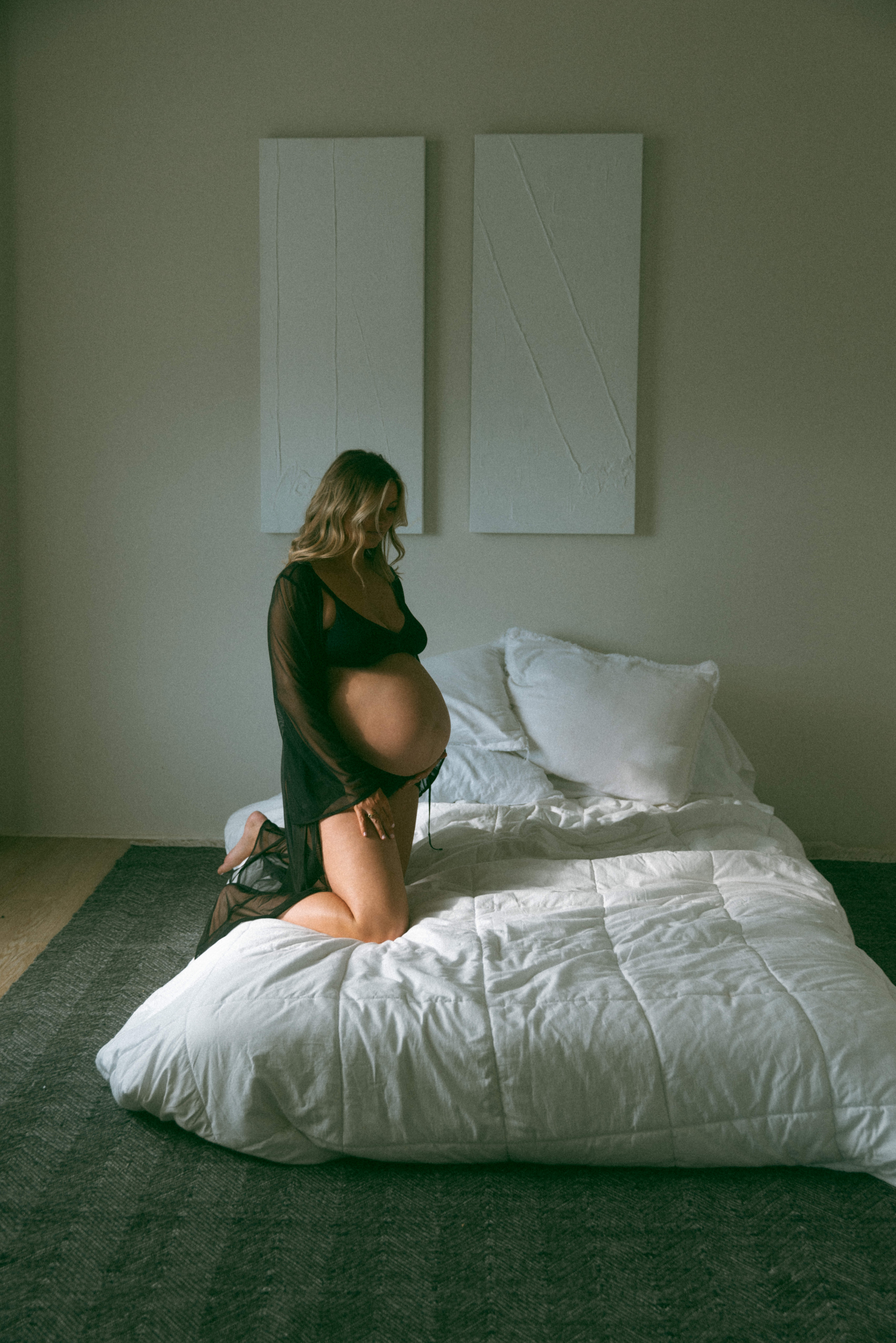 pregnant woman kneeling on a bed during a boudoir maternity shoot in Maryland 