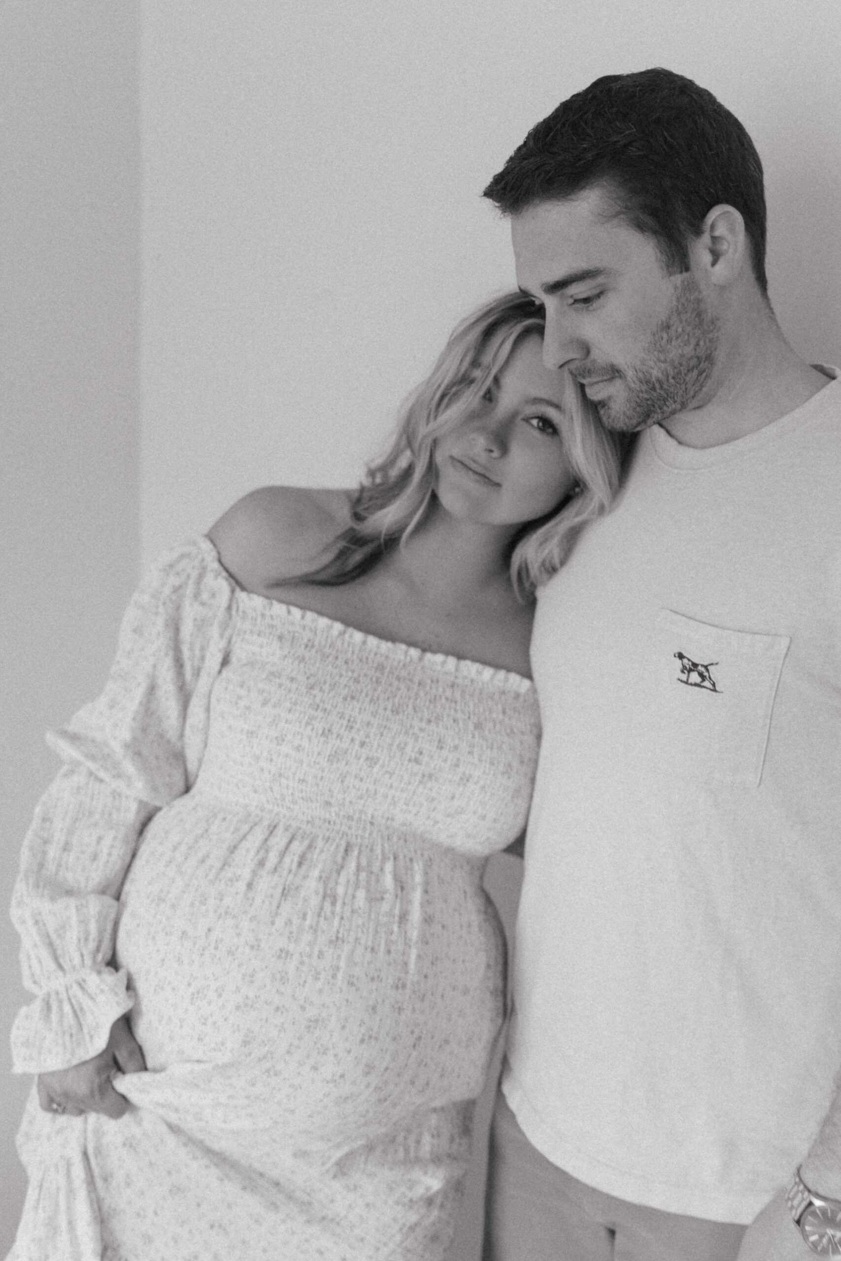 parents leaning into each other during a studio maternity photoshoot