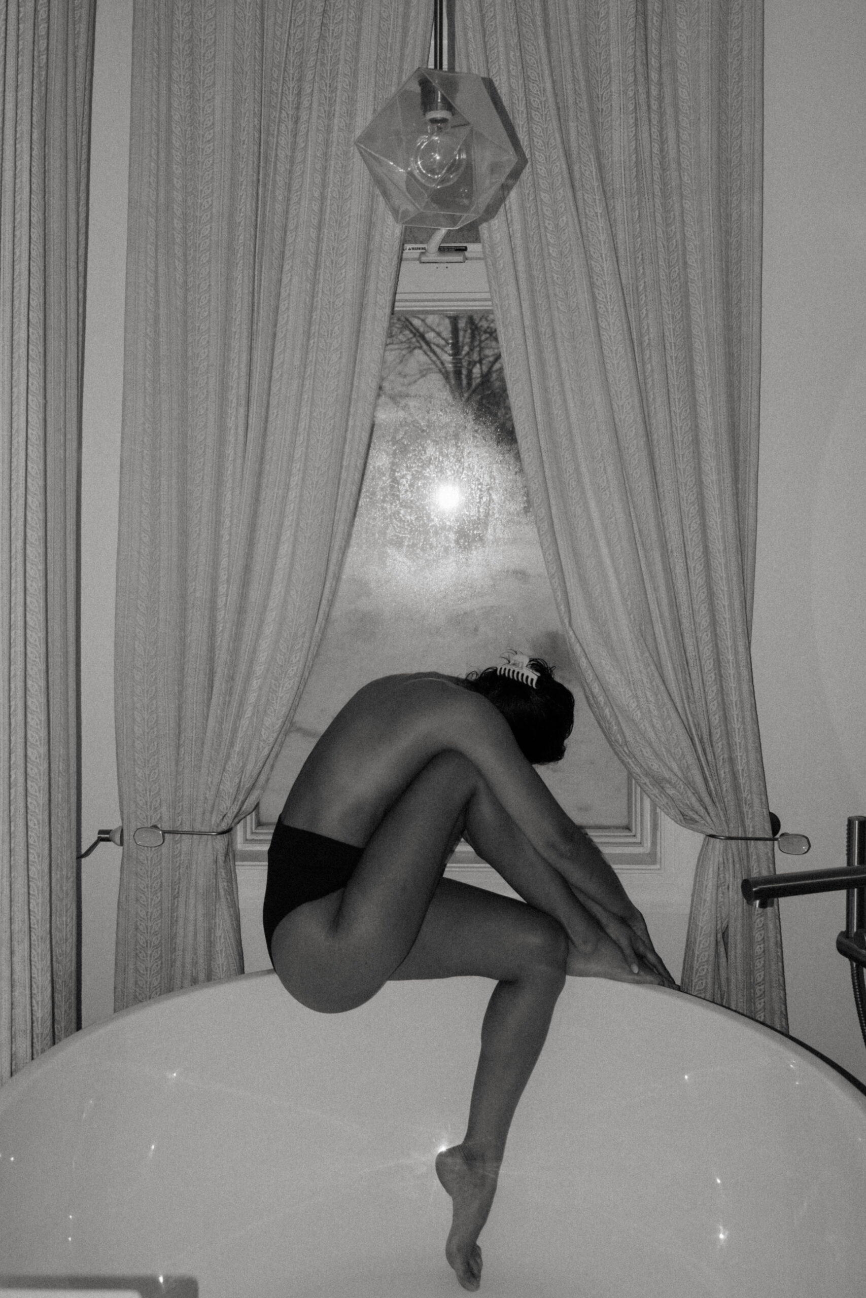 a woman sitting on the tub creatively expressing the word night 