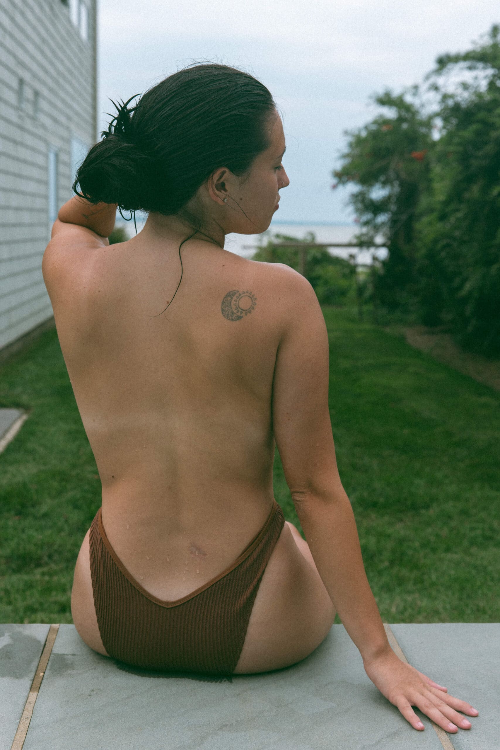 a topless woman's back during and outdoor boudoir session