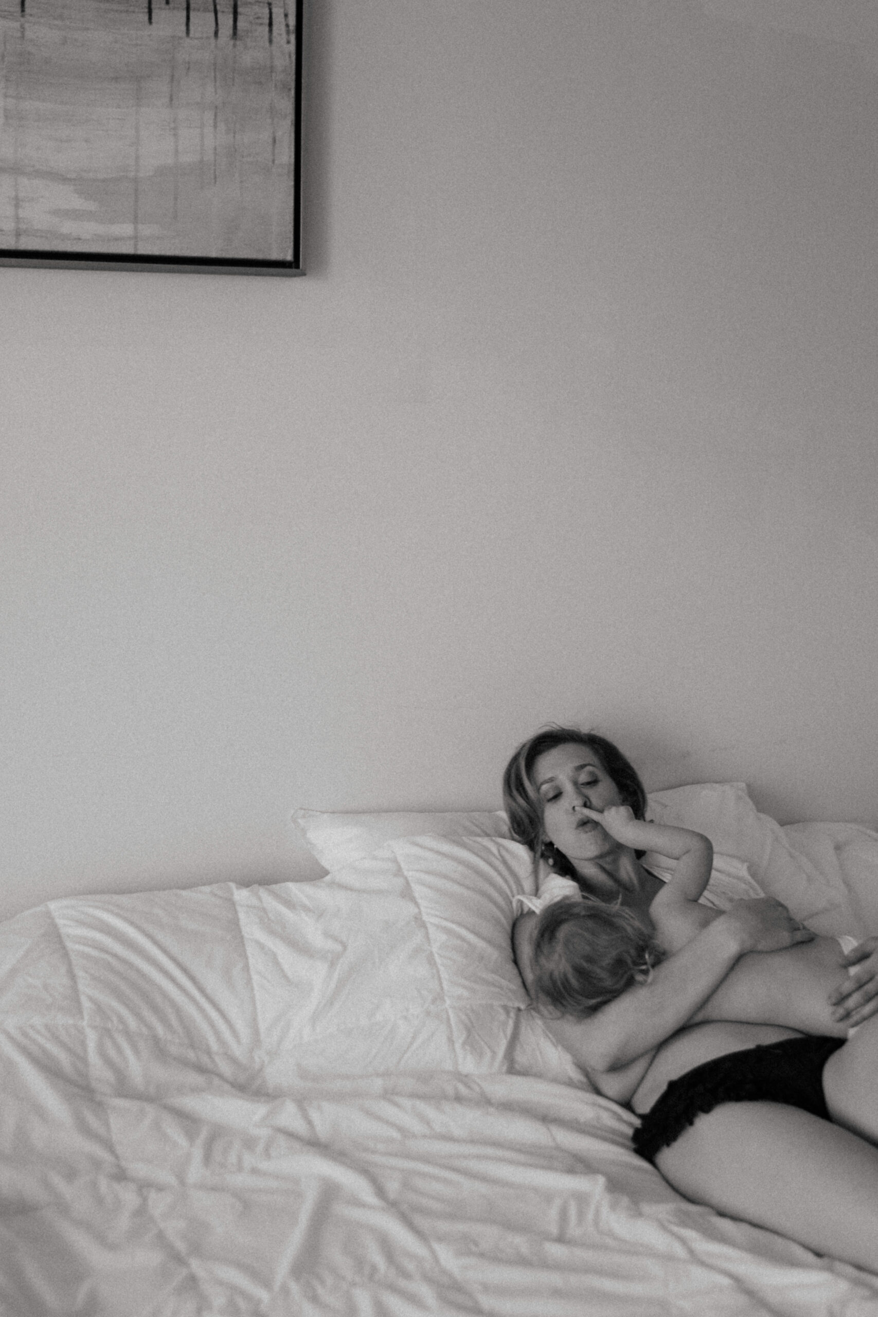 mother and baby in the bed during breastfeeding photography session