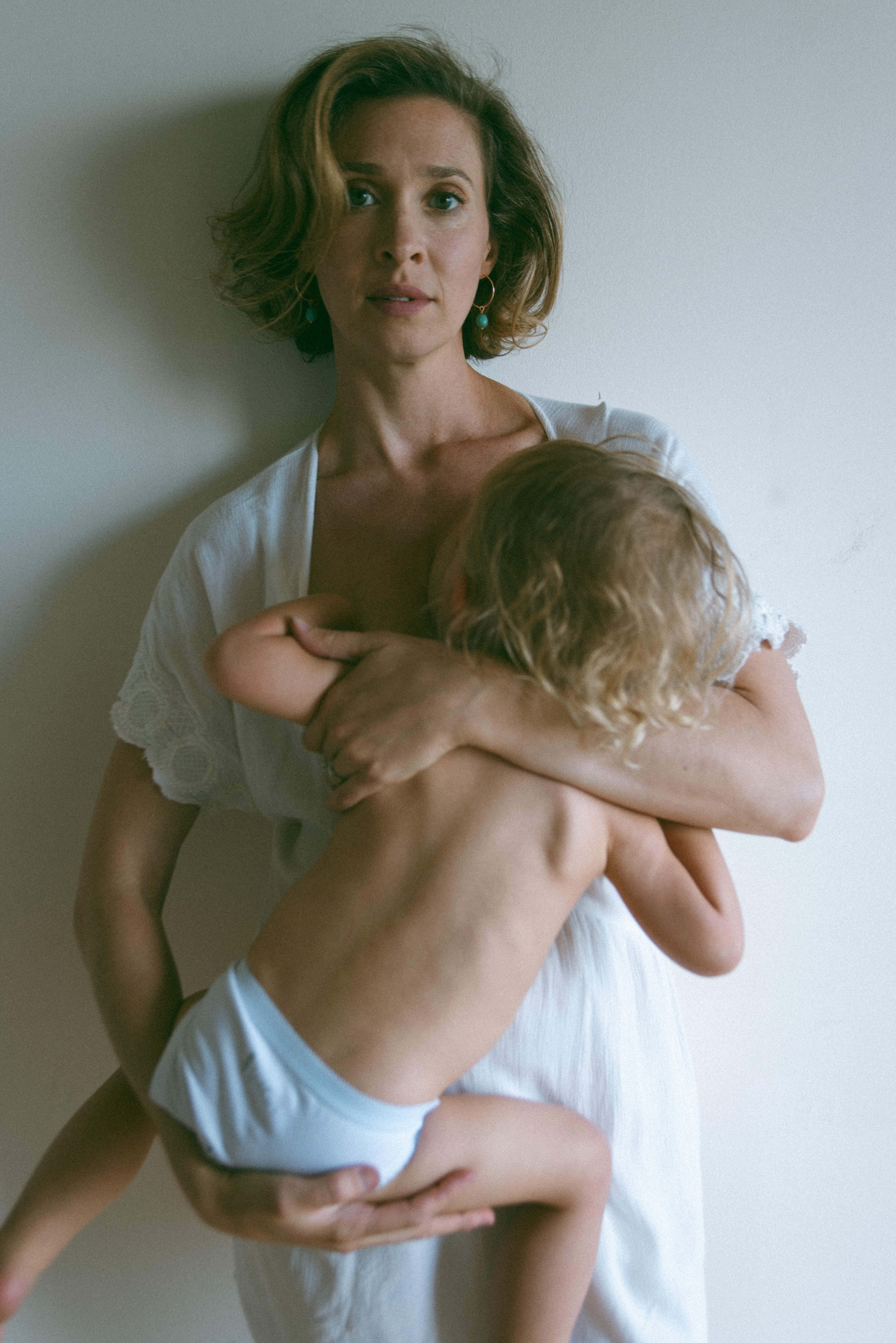 mother standing during breastfeeding photography session