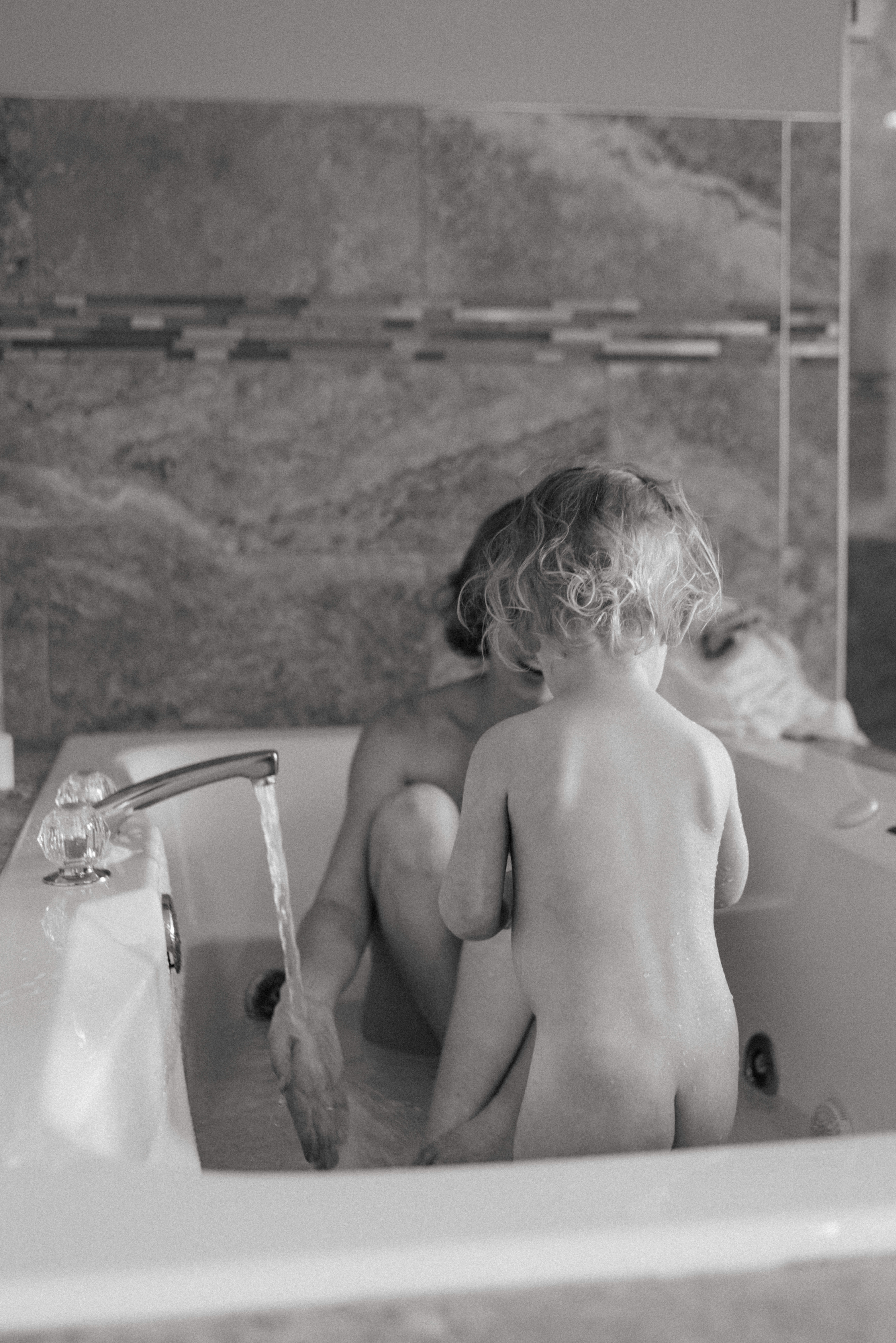 mother and baby in the bathtub during breastfeeding photography session