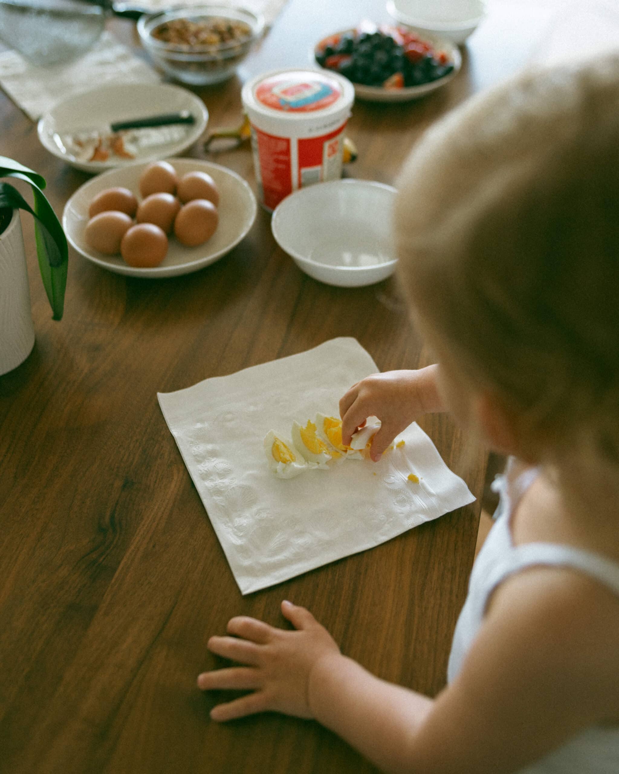 baby eating eggs during in home motherhood session