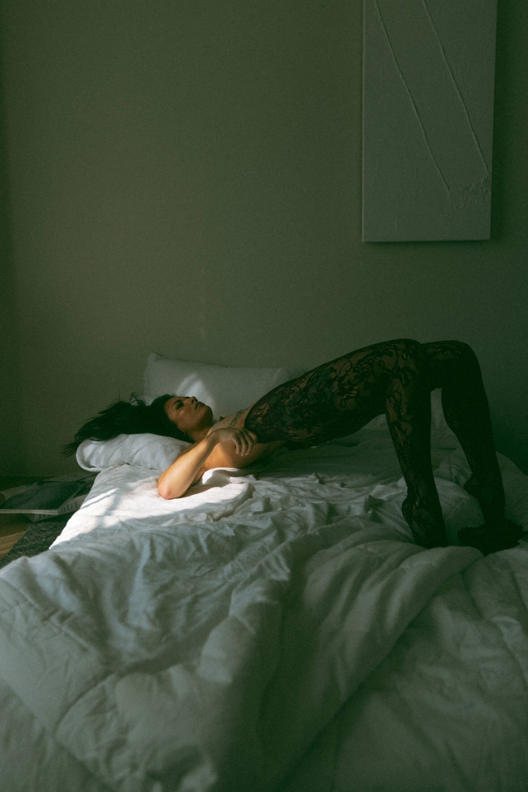 a woman laying on a bed raising her body up during a boudoir photoshoot 
