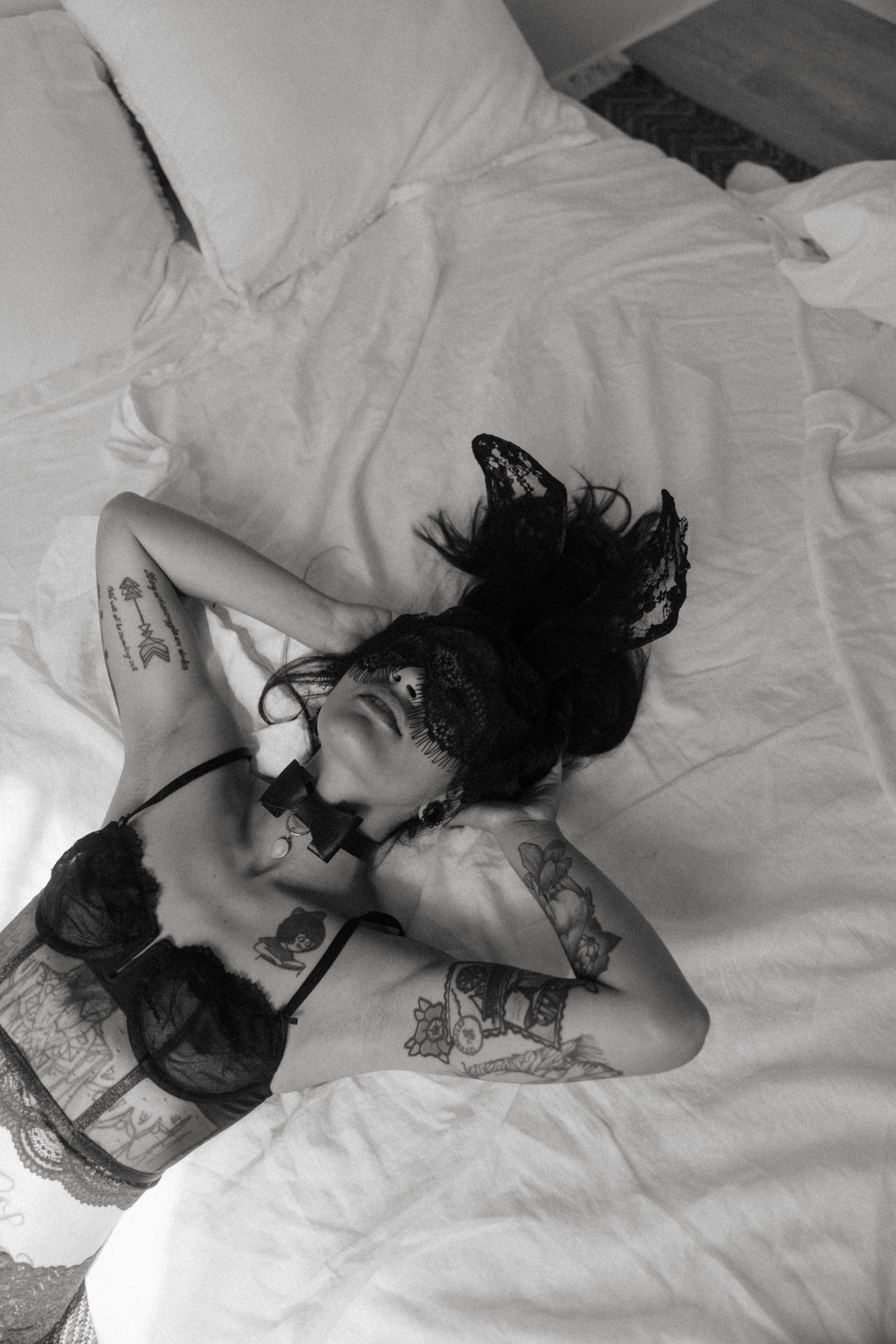 a masked woman in lingerie on a bed showing what is a boudoir photoshoot