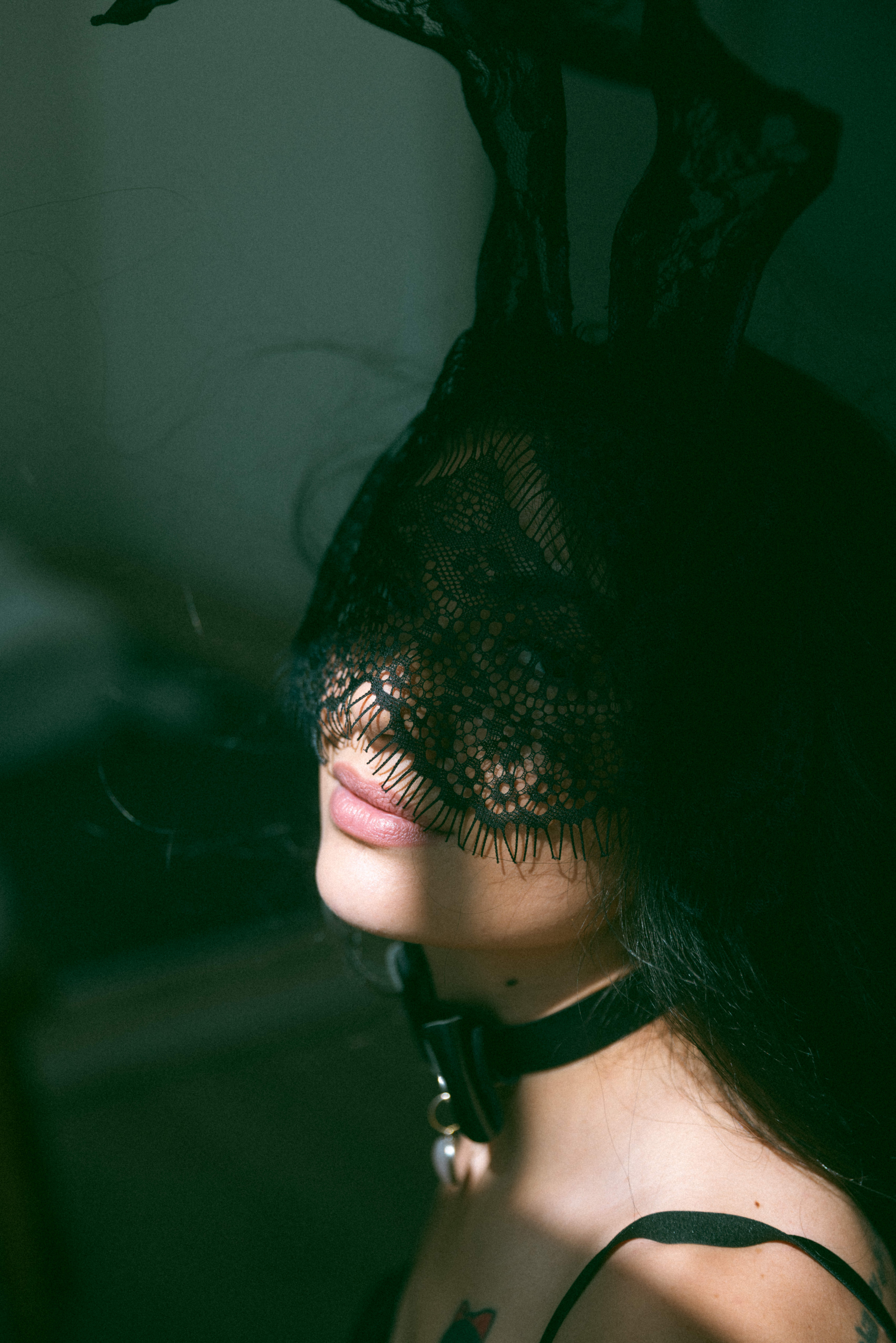 a masked woman with shadows on her face during a boudoir photoshoot 