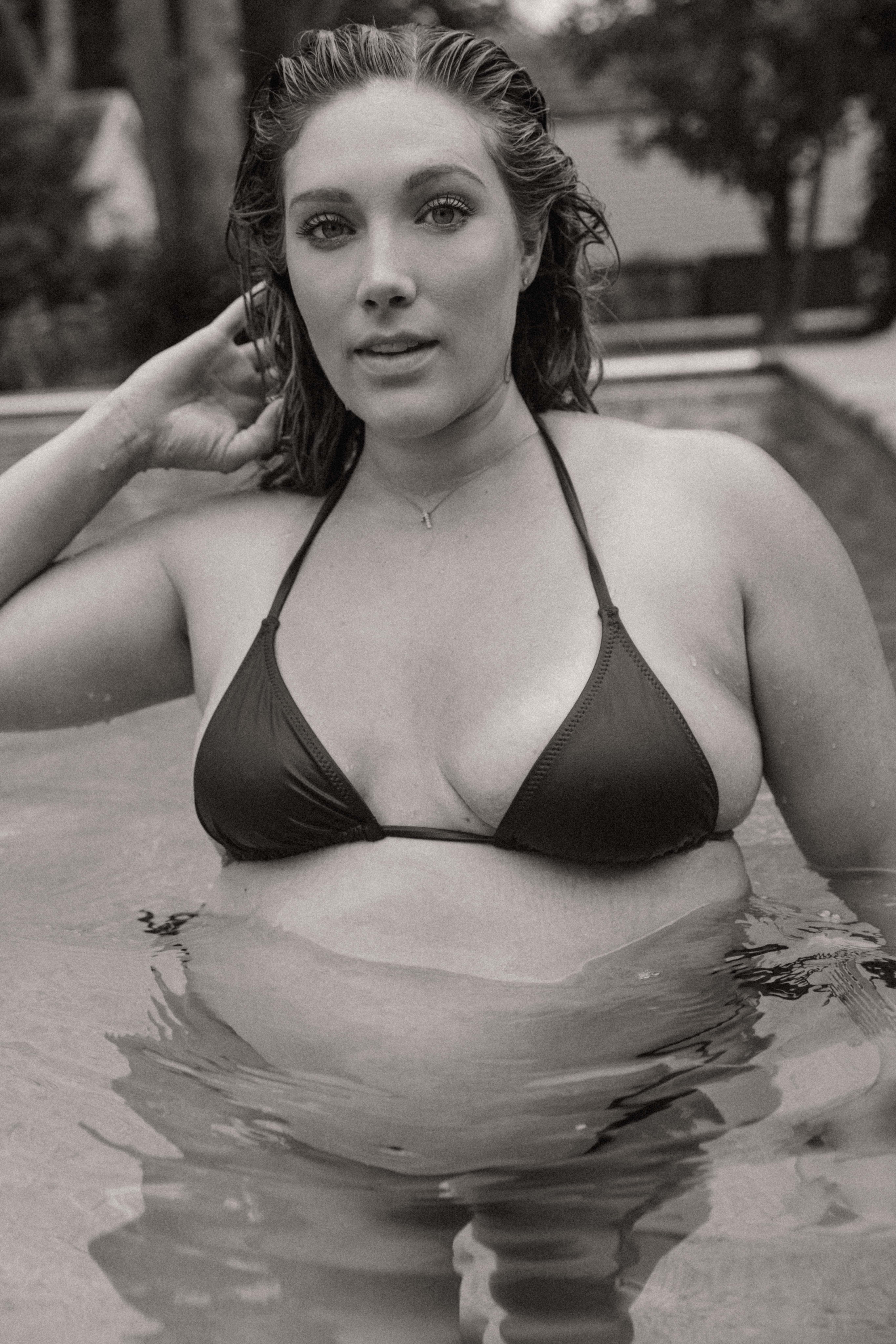 a pregnant woman standing in a swimming pool 