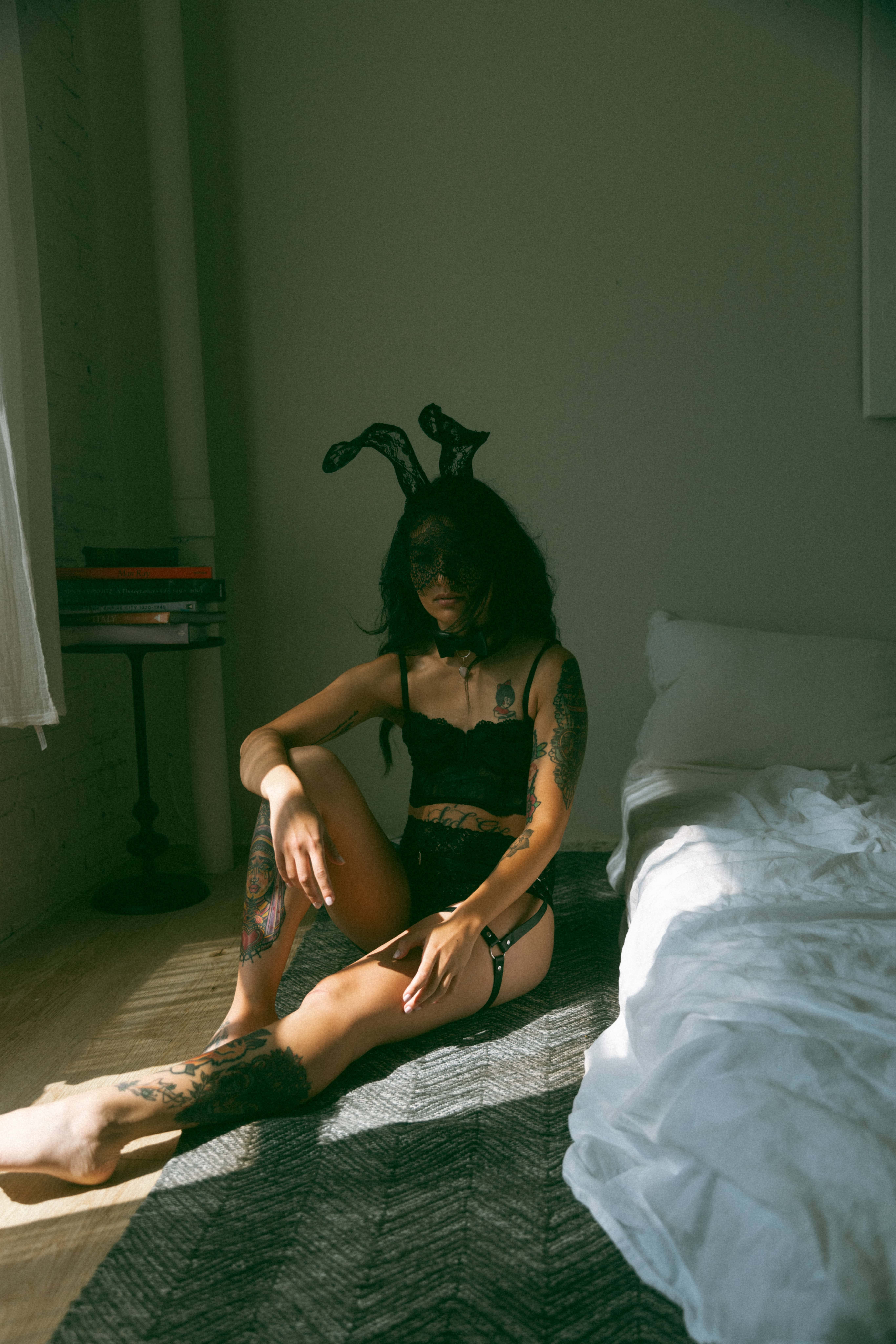 a woman wearing black lingerie and a mask during a maryland boudoir photography session 