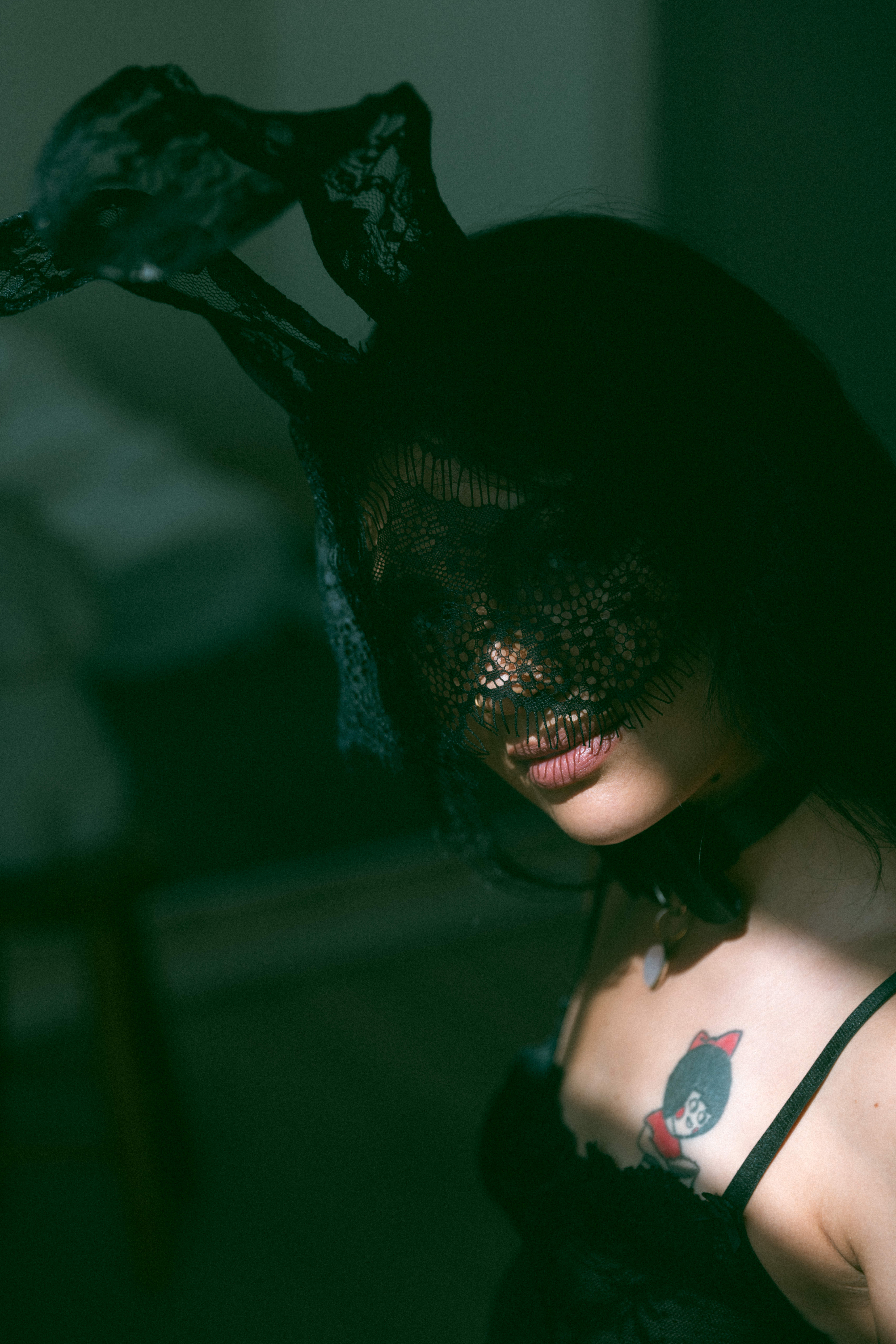 a woman with a black lace mask on during a maryland boudoir photography session 
