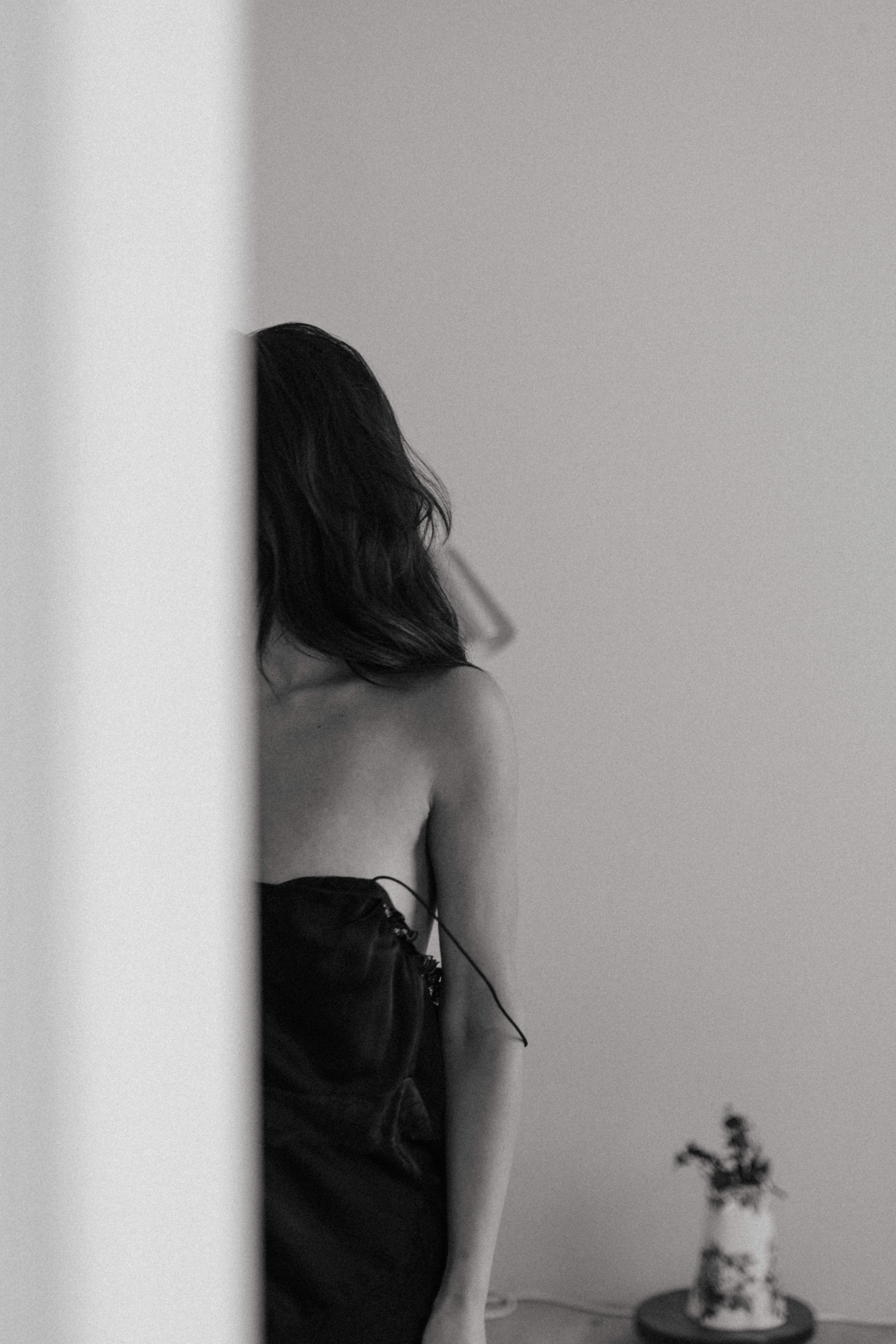 a woman behind a corner during a maryland boudoir photography session 