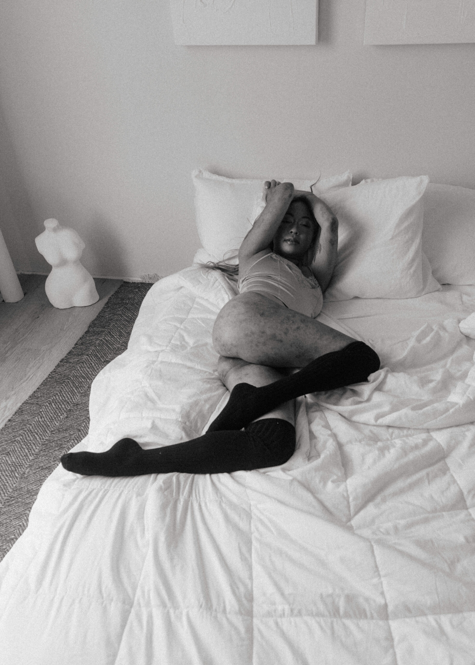 a woman in lingerie laying in a bed during a boudoir shoot 