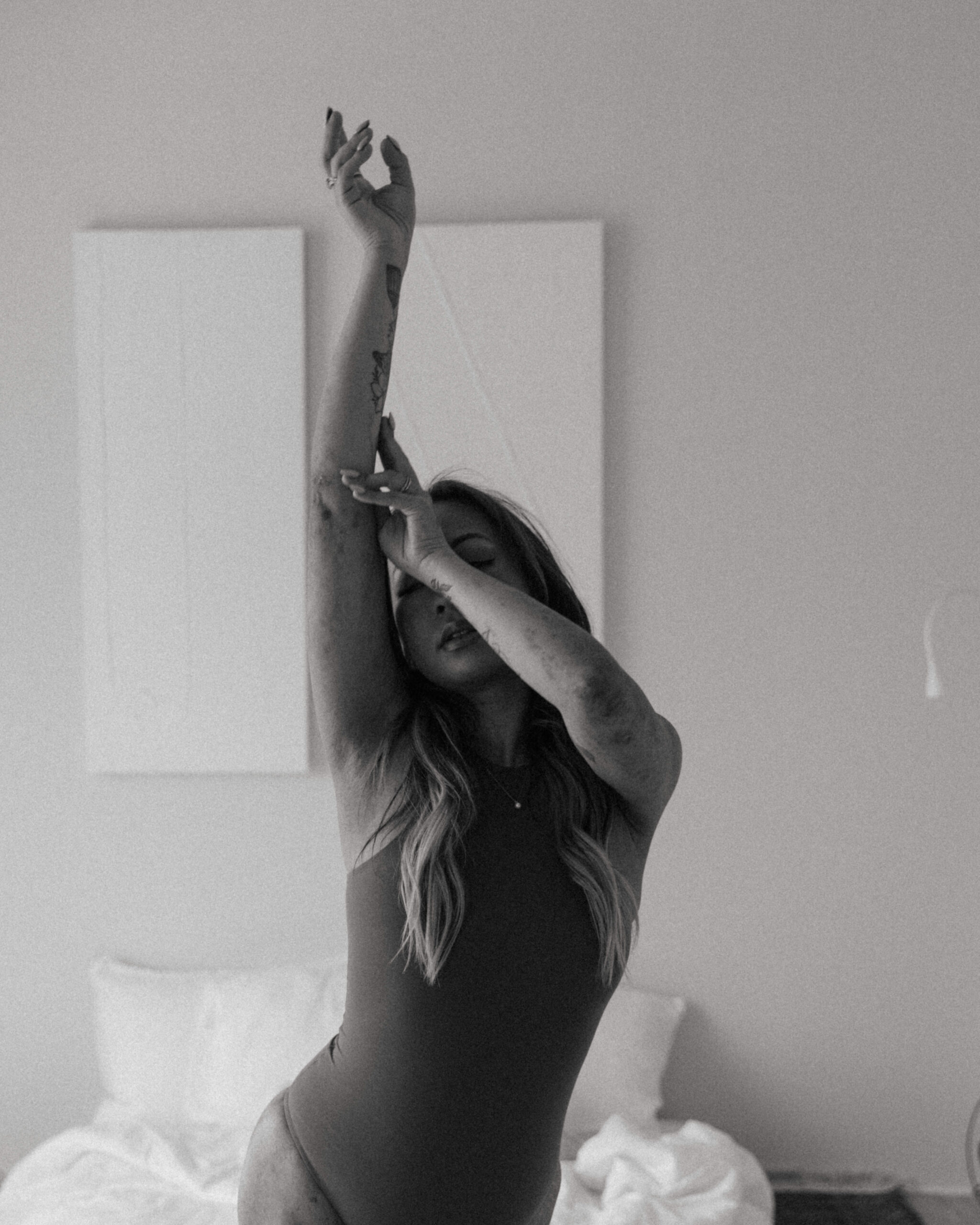 a woman dancing with her arms up during a boudoir artistic collaboration with Winnie